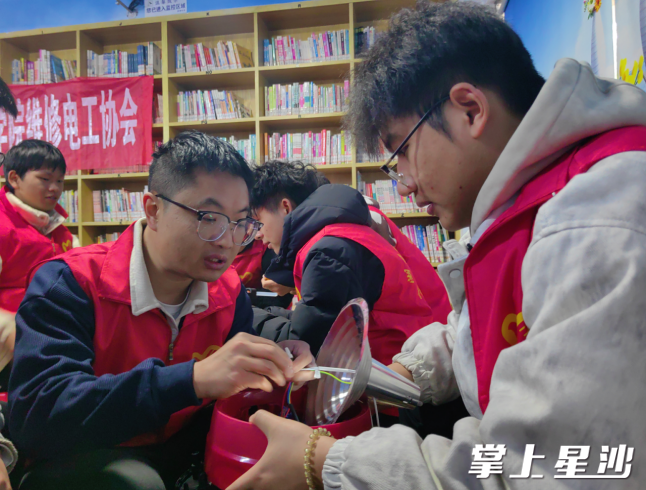 大学教师王彬带领“电系万家”志愿服务队大学生志愿者开展义务维修家电学雷锋文明实践活动。 长沙县文明办供图