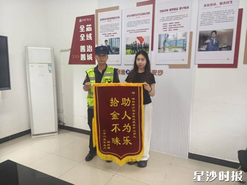 失主杨玥（右）为物业公司送来锦旗。