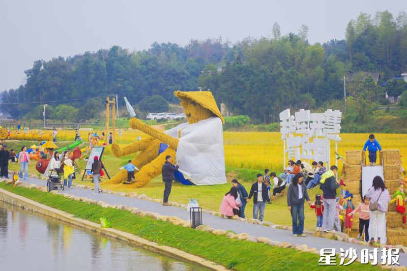 “我在开慧有丘田”的田埂上，孩子们穿梭在巨型稻草人旁嬉戏。章帝 摄