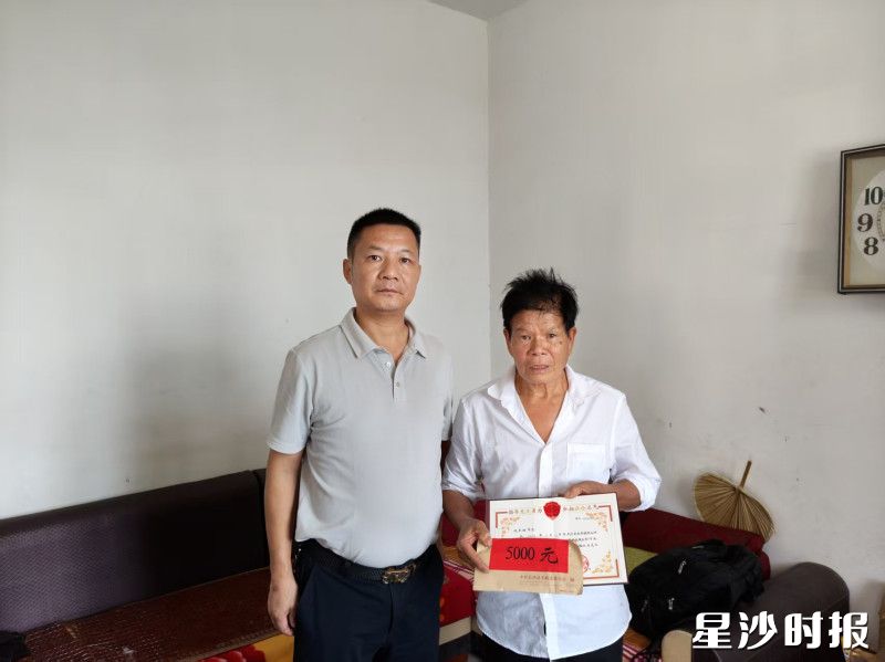 金井镇张腊明（离世）、饶军树（右一）获中央政法委通报表扬和奖励慰问。金井镇供图