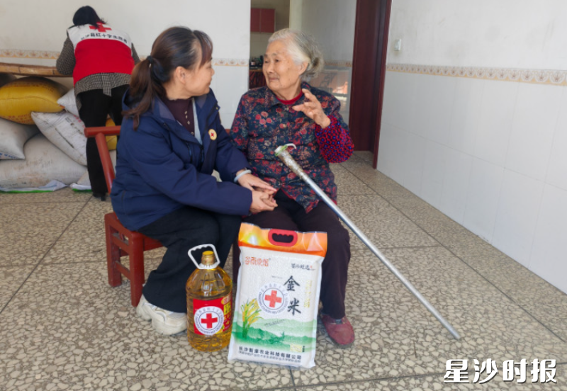 图为谭小勇在看望困难群众。县红十字会供图