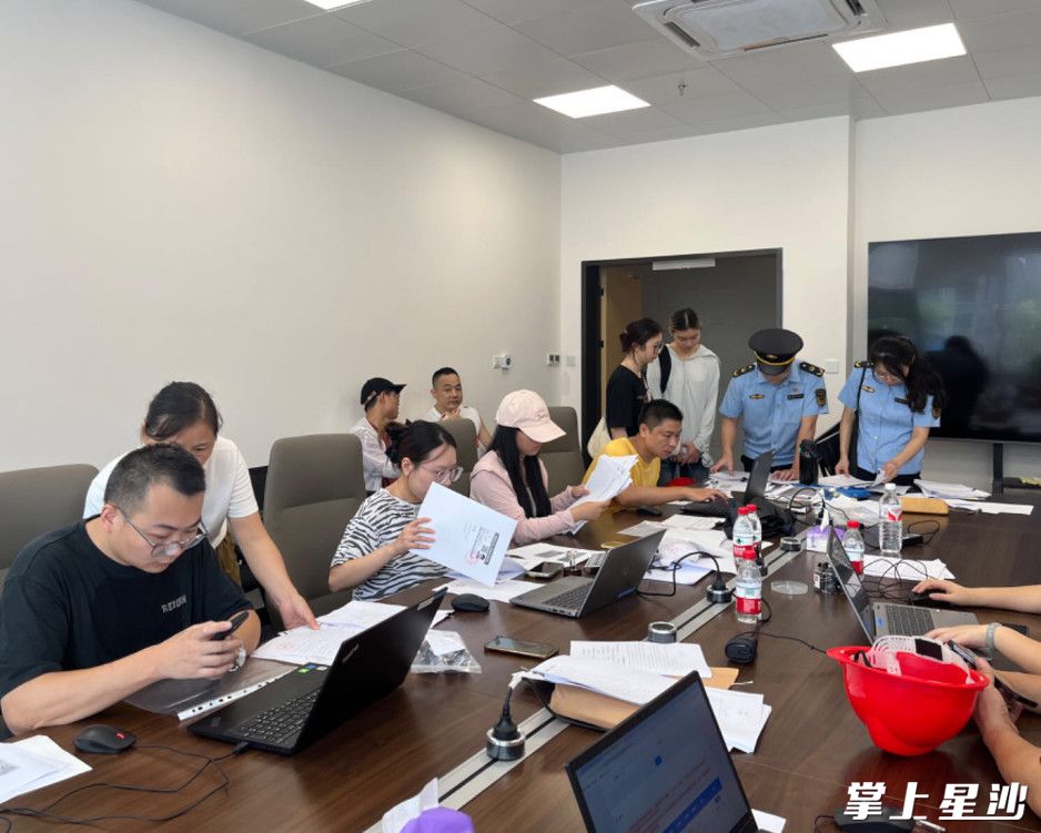图为永旺梦乐城后勤办公室内，长沙县市监局工作人员正在指导商户申办营业执照和食品经营许可证。均为尹理 摄