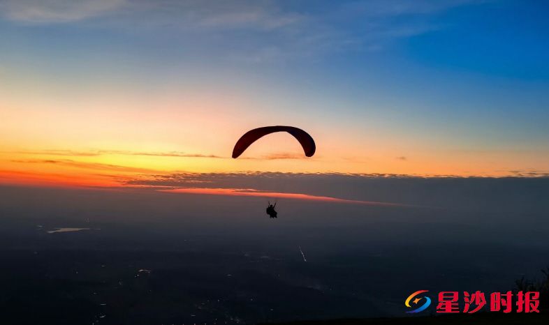 　　夕阳美景下，凌波正在飞滑翔伞。