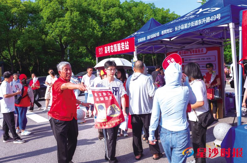 　　“湖南好人”陈小明引导考生从对应通道入场。　　刘思源 摄