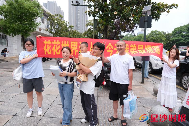 　　在长沙县实验中学考点，弟弟高考结束，姐姐拉横幅迎接：“花花世界迷人眼，今天我弟最耀眼！” 李杰 摄