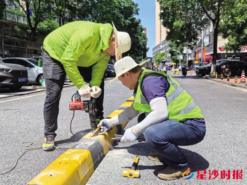 　　施工人员正在大屋路安装中央隔离石条，使得车辆通行更有序，有效解决乱停放问题。郭银 摄