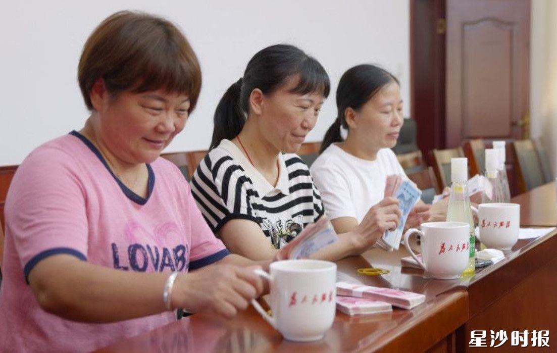 村民拿到分红，喜笑颜开。