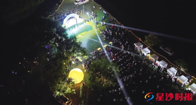 　　安沙草地露营音乐会现场，人流如织，灯光与星光共融，茶香、咖啡香与酒香交织，一幅惬意景象。　　艾哲文 摄