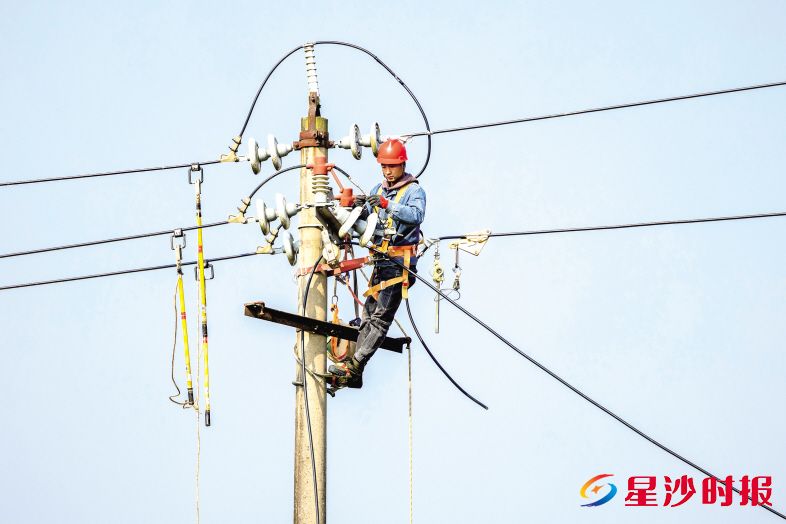 国网长沙县供电公司黄花供电所工作人员正在进行杆线迁移。杨源 摄