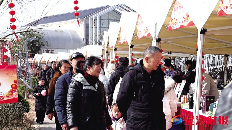 　　在长沙县果园镇，一场以“品星城特产·寻马年年味”为主题的嘉年华火热上演。乡村集市人头攒动，现场居民参观年货展览，热闹非凡。　　杨源 摄