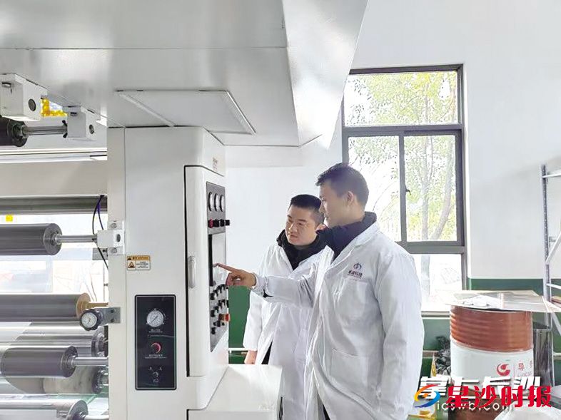 　　袁乐（右一）和同事在调试原材料配比数据。 资料图片