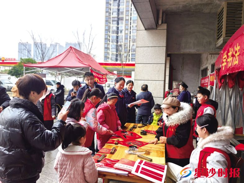 　　花园村年货大集便民服务活动现场，居民们正在领取志愿者们手写的福字春联。花园村供图