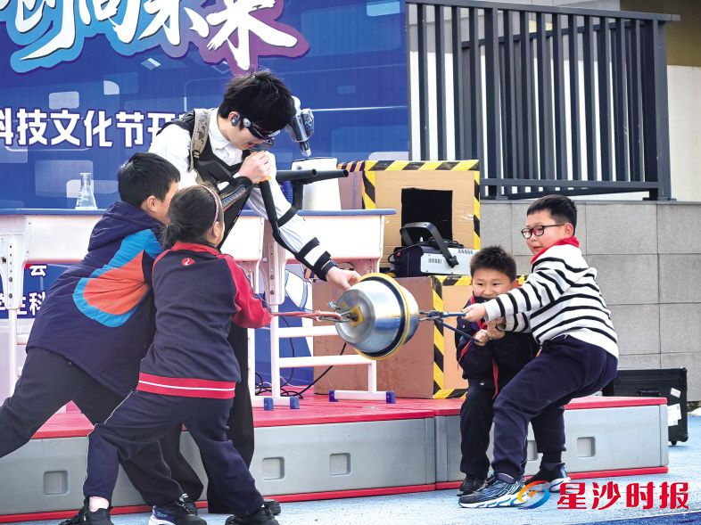 在长沙麓山国际松湖小学第二届科技文化节上,孩子们与老师合力体验大气压强实验,趣味十足。 学校供图