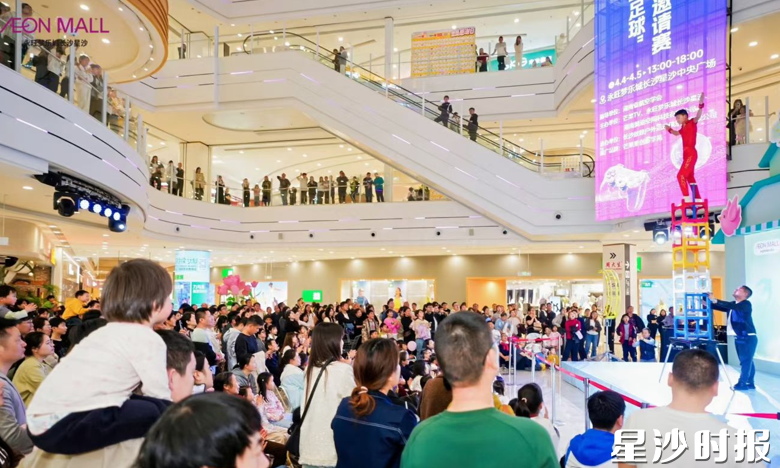 永旺梦乐城商场内上演高空杂技秀，吸引了众多前来消费的市民观看。永旺梦乐城供图