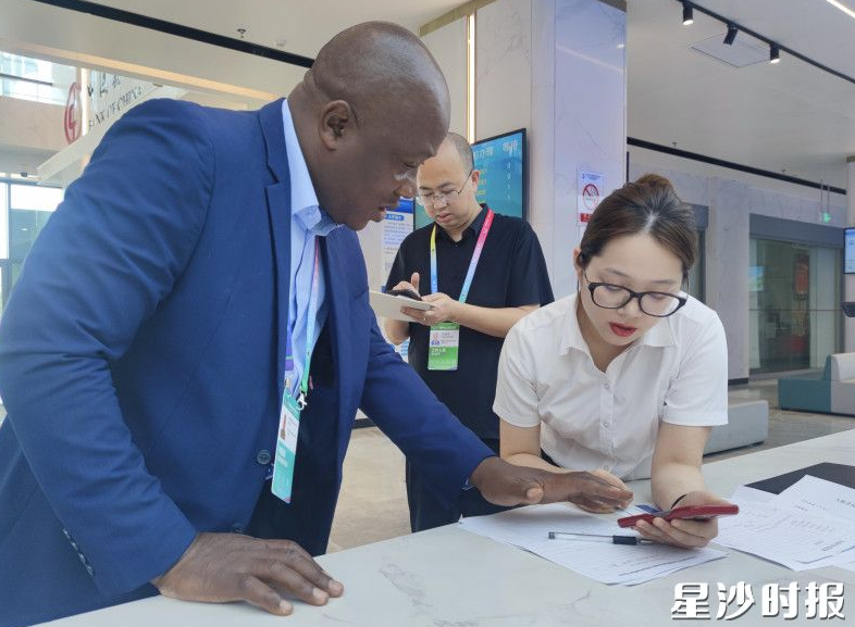 在长沙自贸临空区政务服务大厅，工作人员跟非洲客商交流。长沙自贸临空区供图
