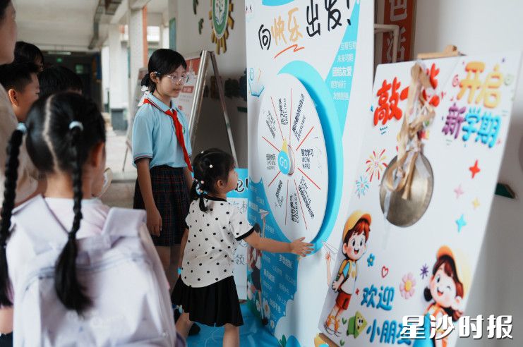 长沙市花园小学设置趣味转盘打卡点,小朋友伸手转动幸运转盘,在互动游戏中收获开学的欢乐。