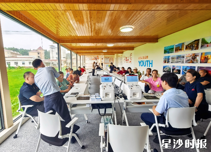 星沙农商银行工作人员在江背镇为村民集体办理社保卡，切实打通助老服务“最后一米”。